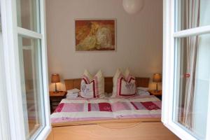 een slaapkamer met een bed met roze en witte kussens bij Bernsteinstube Wolf in Hermannsburg