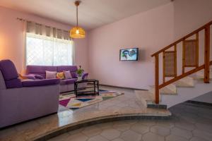 salon z fioletową kanapą i schodami w obiekcie Butterfly House w mieście Trappeto