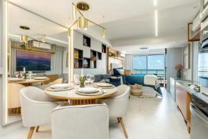a dining room and living room with a table and chairs at Deluxe Flats Praia Natal in Natal