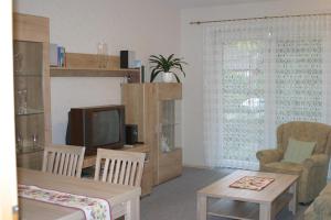 a living room with a television and a table and chairs at Ferienwohnung Am Hasenberg in Hermannsburg