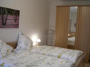 a bedroom with a bed with a white comforter at Ferienwohnung Am Hasenberg in Hermannsburg