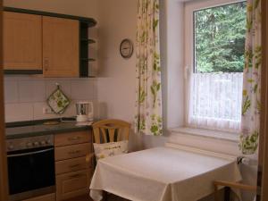 a kitchen with a table in front of a window at Ferienwohnung Am Hasenberg in Hermannsburg +3 photos