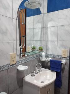 y baño con lavabo y espejo. en Alojamiento Turístico Los Pinos en Villa Elisa