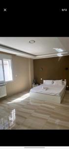 ein Schlafzimmer mit einem weißen Bett und einem Fenster in der Unterkunft Jijel in Oum el Bouaghi