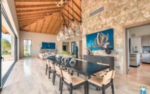 Holiday Villa 72 في San Rafael del Yuma: غرفة طعام مع طاولة سوداء وكراسي