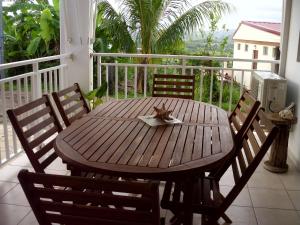 drewniany stół i krzesła na balkonie w obiekcie Villa Ducos w mieście Ducos