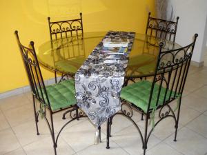 szklany stół z 4 krzesłami oraz szklany stół i krzesła w obiekcie Villa Ducos w mieście Ducos