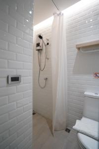 a white shower with a shower curtain in a bathroom at W 21 Hotel Bangkok in Bangkok
