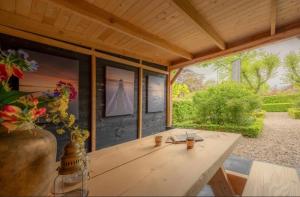 einen Holztisch in einem Zimmer mit einem großen Fenster in der Unterkunft Bed and Breakfast Waddendroom in Lioessens