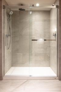 y baño con ducha y puerta de cristal. en Hôtel-Musée Premières Nations, en Wendake