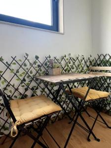 a table and two chairs in front of a wall at Smart Living in Aveiro
