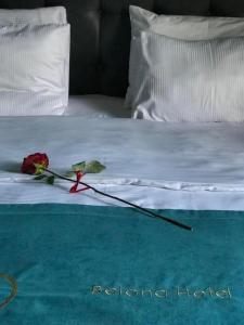 una rosa su un letto con un fiore sopra di Belona Hotel a Kutaisi