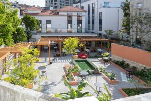 una vista aérea de un patio con mesas y árboles en The Editory Garden Porto Hotel en Oporto