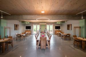 une salle à manger avec des tables et des chaises en bois dans l'établissement Podere Vignanova Rooms & SPA, à Castagneto Carducci