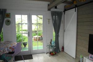 een kamer met een glazen schuifdeur en een raam bij B&B Öland in Ottoland