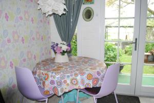 d'une table avec des chaises violettes et un vase de fleurs. dans l'établissement B&B Öland, à Ottoland