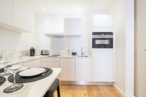 a kitchen with white cabinets and a counter top at SERRENDY NEW 1-bedroom apartment in the city center in Cannes