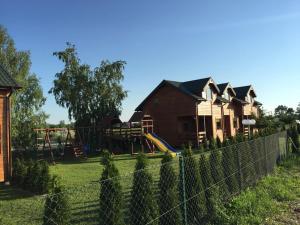 a house with a playground behind a fence at Nika Resort in Rusinowo