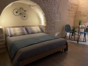 Regina Bona Rooms في مودونيو: غرفة نوم مع سرير مع دراجة على الحائط
