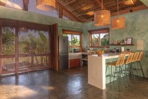 a kitchen with a refrigerator and a counter with chairs at Tanaw Villas in General Luna