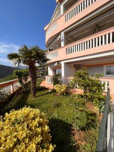 a building with a palm tree in front of it at Apartments Gojević in Crikvenica