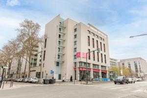 um edifício branco na esquina de uma rua em Appart’City Confort Lyon Gerland em Lyon