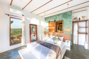 a bedroom with a large bed and a large window at Tanaw Villas in General Luna