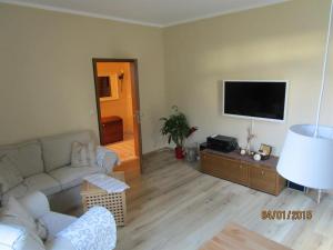 a living room with a couch and a flat screen tv at Ferienwohnung Hartmann in Hermannsburg