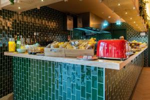 a restaurant with a counter with bread on it at The Editory Garden Porto Hotel in Porto