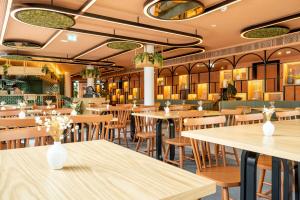a restaurant with tables and chairs in a room at The Editory Garden Porto Hotel in Porto