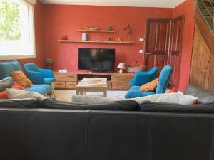 a living room with a large couch and blue chairs at Le Trolle in Saint-Pons +11 photos