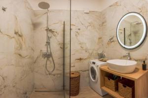 La salle de bains est pourvue d'une douche, d'un lavabo et d'un lave-linge. dans l'établissement Luksuzni apartman Ribica u samom centru grada, à Split