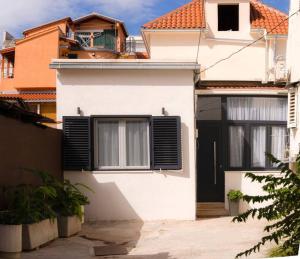 une maison blanche avec une porte et des fenêtres noires dans l'établissement Luksuzni apartman Ribica u samom centru grada, à Split