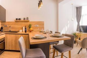 - une cuisine avec une table en bois, des chaises et un évier dans l'établissement Luksuzni apartman Ribica u samom centru grada, à Split