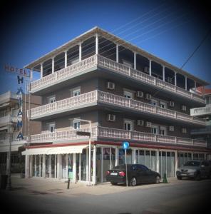 a large building with cars parked in front of it at Iliana Hotel Paralia in Paralia Katerinis