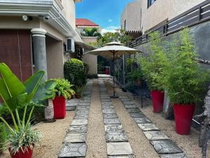 un patio con plantas y una sombrilla en una casa en Your perfect getaway ..., en Palmyre