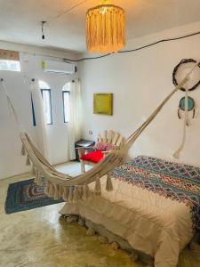 um quarto com uma cama de rede num quarto em Casa Iguana em Ilha das Mulheres