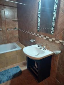 a bathroom with a sink and a bath tub at Sol y Luna B&B in Monte Grande
