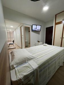 a bedroom with a bed and a tv on the wall at Xikus Palace Hotel in Guanhães