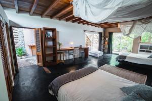 Villa Del Sol في مانكورا: غرفة نوم بسريرين ومكتب