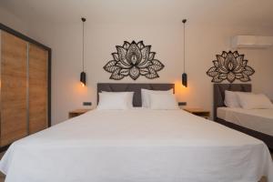 a bedroom with a large white bed and two mirrors at Sea Valley Lodge in Faralya