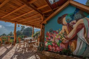 Casa Chuparrosas في San Mateo Río Hondo: لوحة جدارية على جانب منزل مع طاولة وكراسي