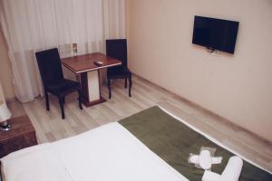 a hotel room with a table and chairs and a television at Nord West Hotel in Baku