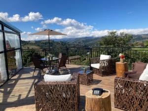 eine Terrasse mit Stühlen, einem Tisch und einem Sonnenschirm in der Unterkunft Pousada Ville Le Mont in Campos do Jordão