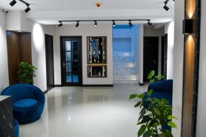 a living room with blue chairs and stairs at Euro Hotel Kutaisi in Kutaisi