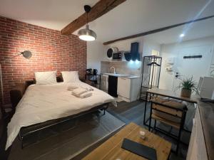 - une chambre avec un lit et un mur en briques dans l'établissement Juliette - Joli Studio Centre Historique Grasse, à Grasse