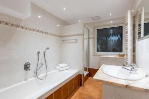 a bathroom with a bath tub and a sink at Katharinenhof in Klingenberg am Main