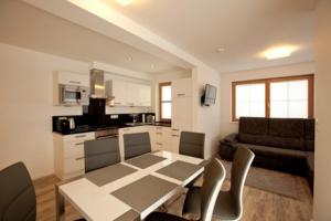 a living room with a table and chairs and a kitchen at A Casa Residenz in Sölden