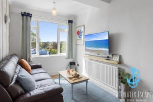 a living room with a couch and a flat screen tv at Stella Marina in Paignton