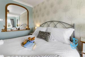 a bedroom with a white bed with a mirror at Stella Marina in Paignton